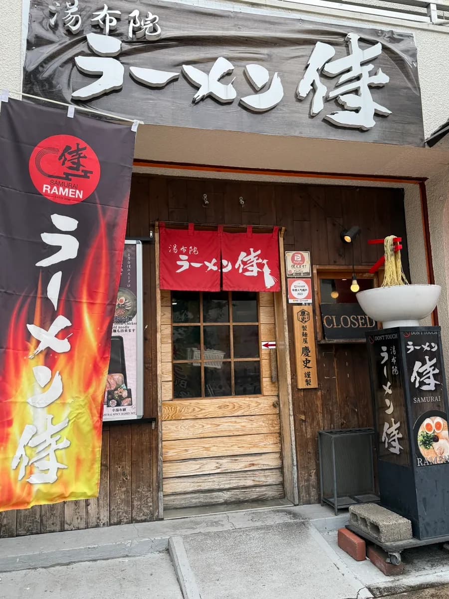 Kawasan luar Samurai Ramen di Yufuin dengan paparan ramen berhampiran pintu masuk