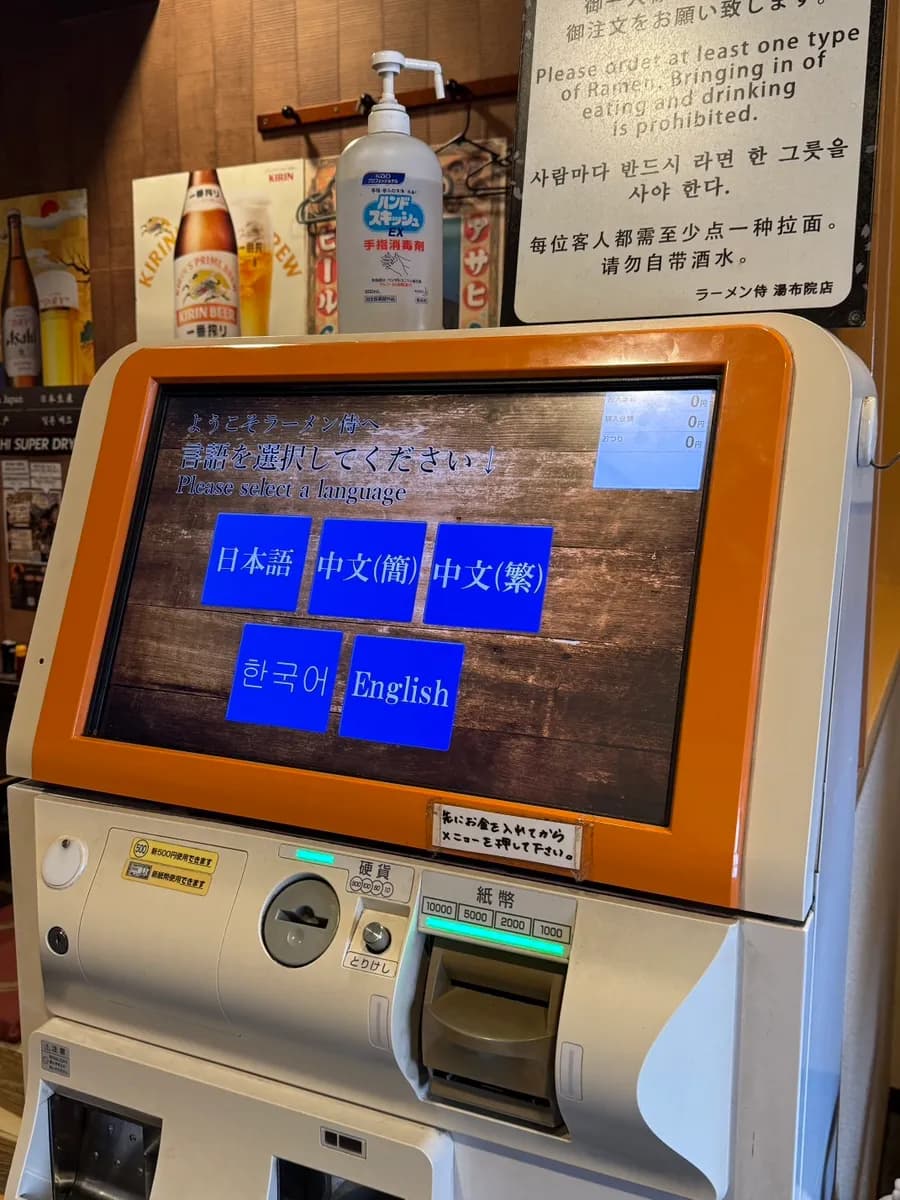 Tempat duduk dalaman dan kawasan kiosk masuk di Samurai Ramen Yufuin