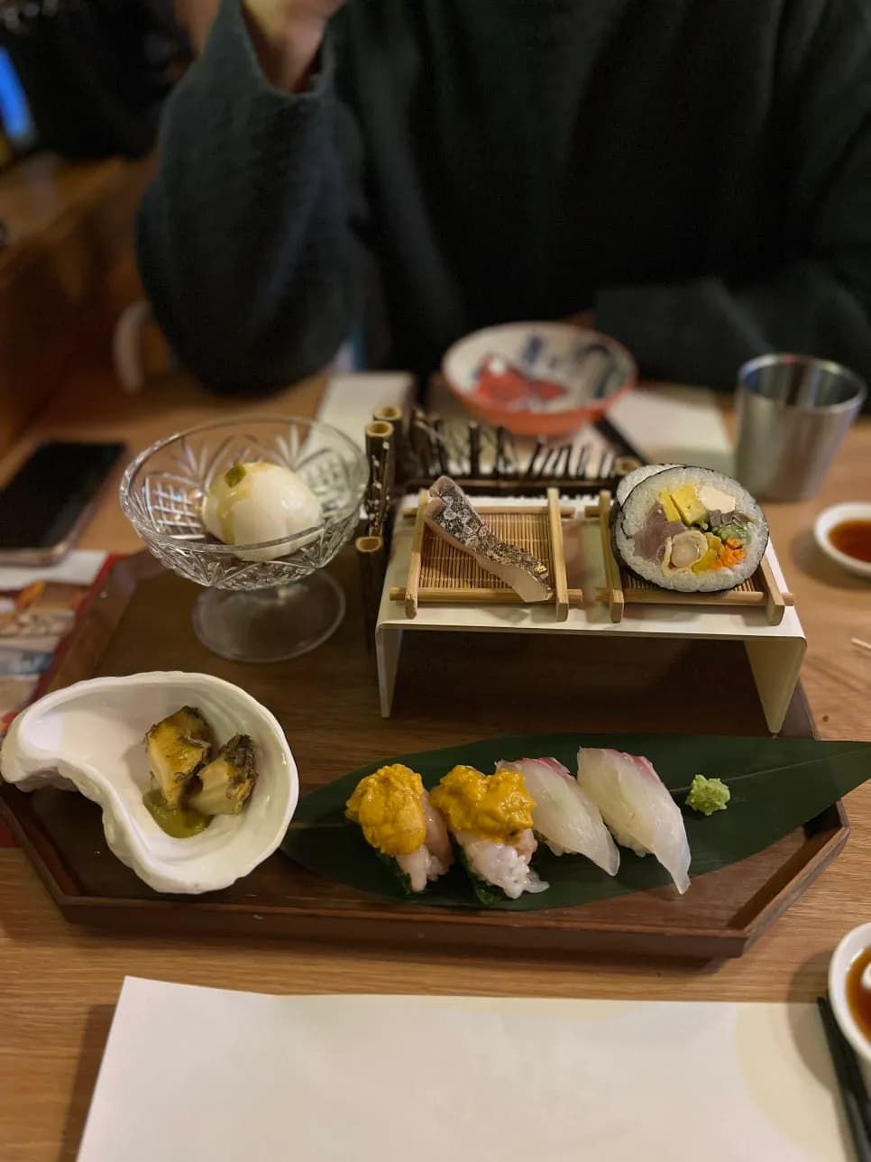 First omakase tray with mochiri tofu, sushi, futomaki, smoked mackerel sashimi, and abalone
