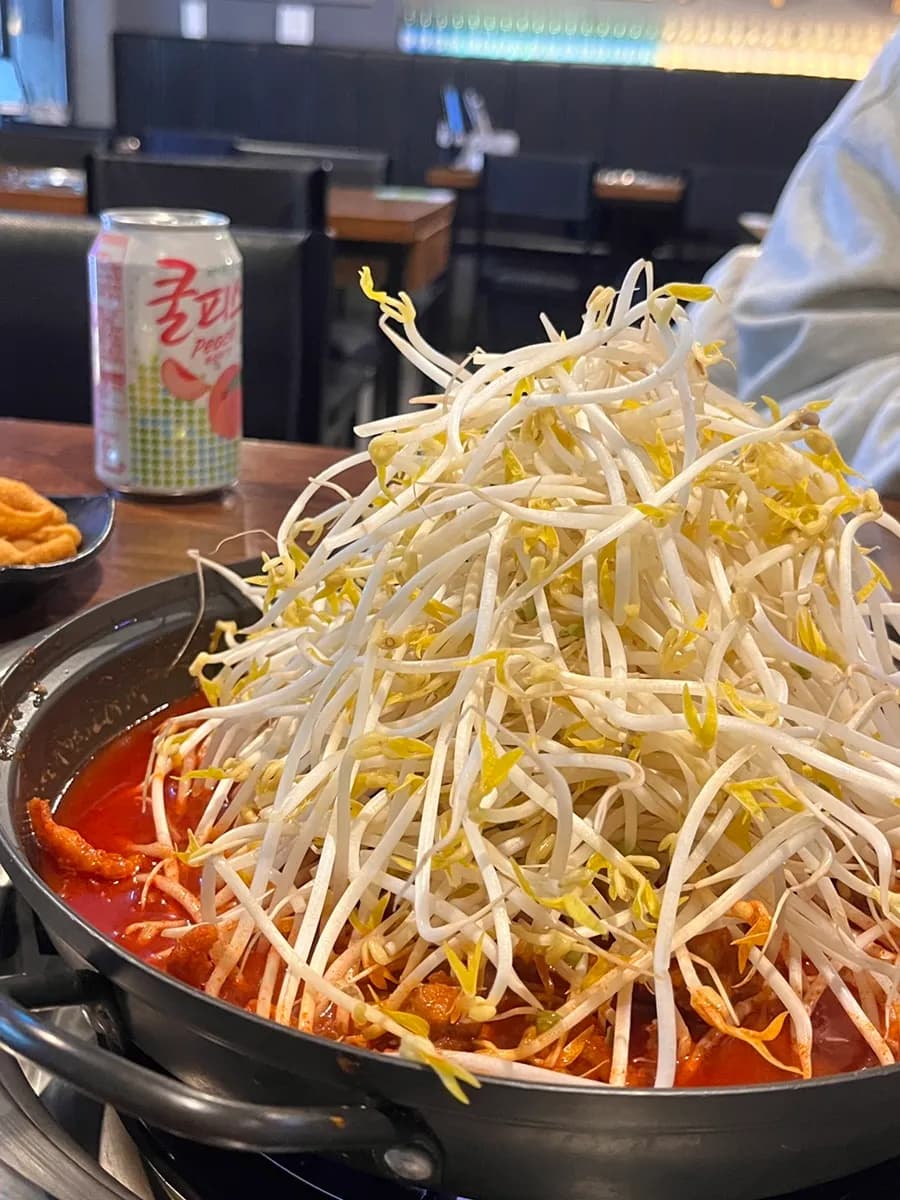 Cheongchun Gungmul Dakbal في Anyang Indeogwon: أقدام دجاج حارة مع جبل من bean sprouts