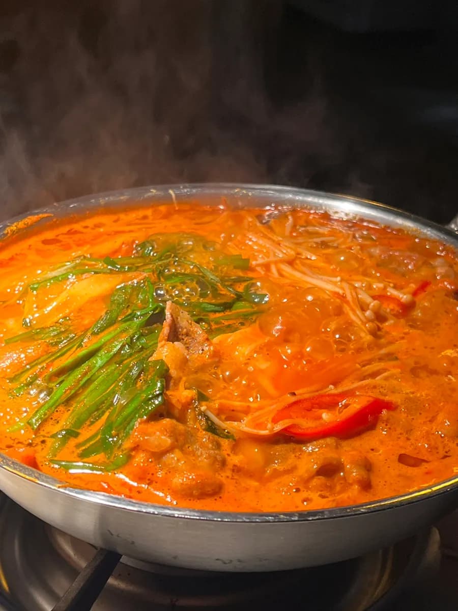 Udon-Nudeln in kochenden Jjambbong-tang geben