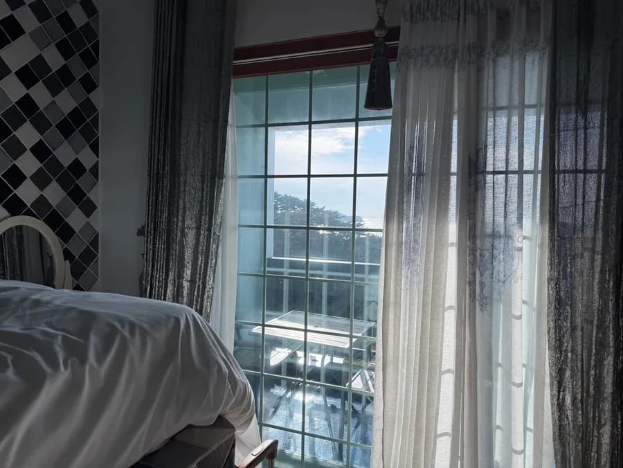 Itinaas na bed area sa Greece Room na may tanawin ng bundok at dagat