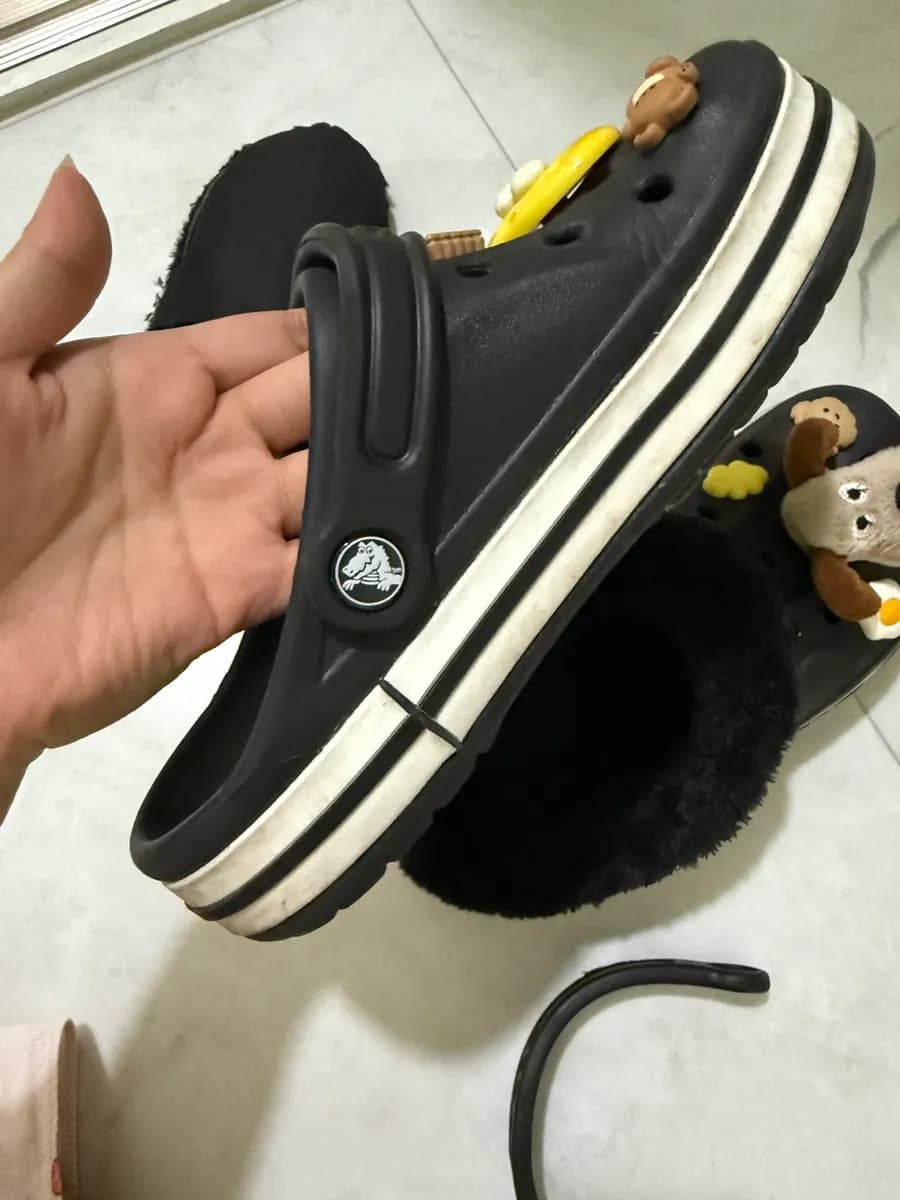 Installing a removable fleece liner by fitting it around the Crocs strap button