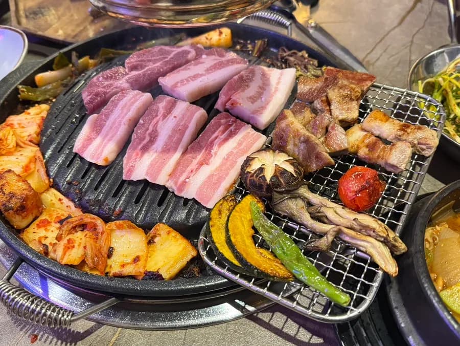 Gereiftes Schweinefleisch, Kimchi und Gemüse garen zusammen auf dem Grill
