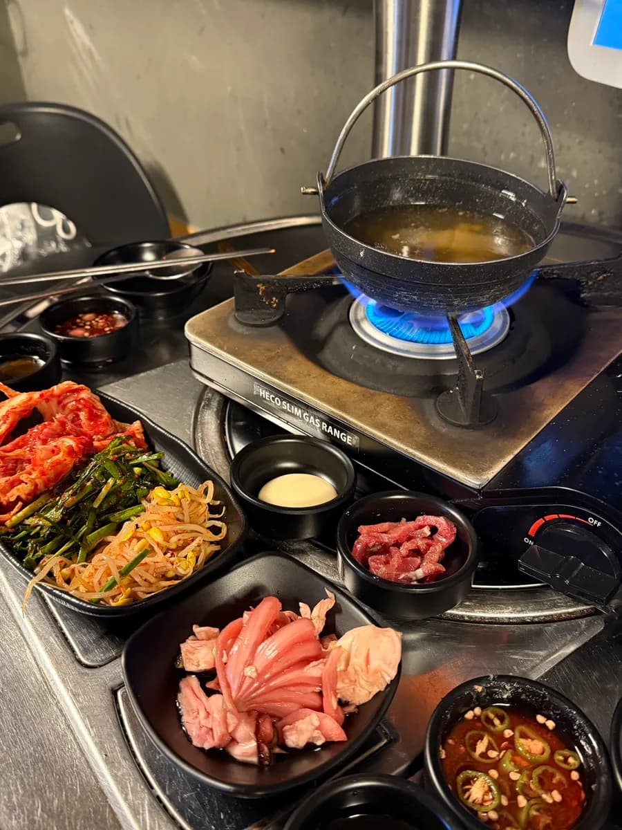 Accompagnements de base chez Geotbasokgop : kimchi, buchu, pousses de soja, yukhoe et soupe de radis au bœuf