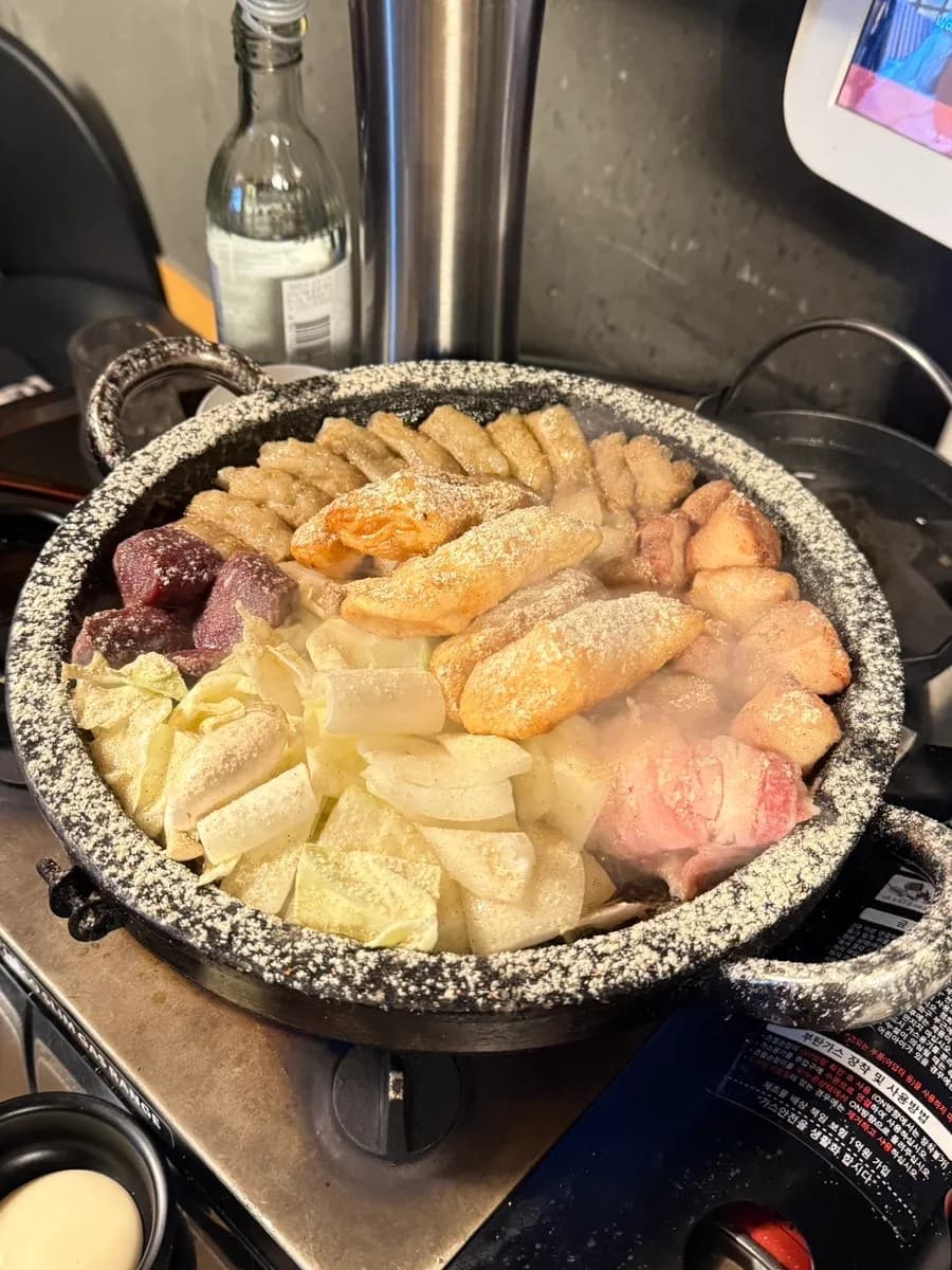 Assortiment de gopchang avec makchang, daechang, tteok et légumes chez Geotbasokgop
