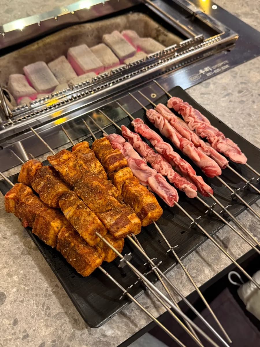 Brochetas de cordero grandes girando sobre la parrilla en un restaurante de Anyang Ilbeonga