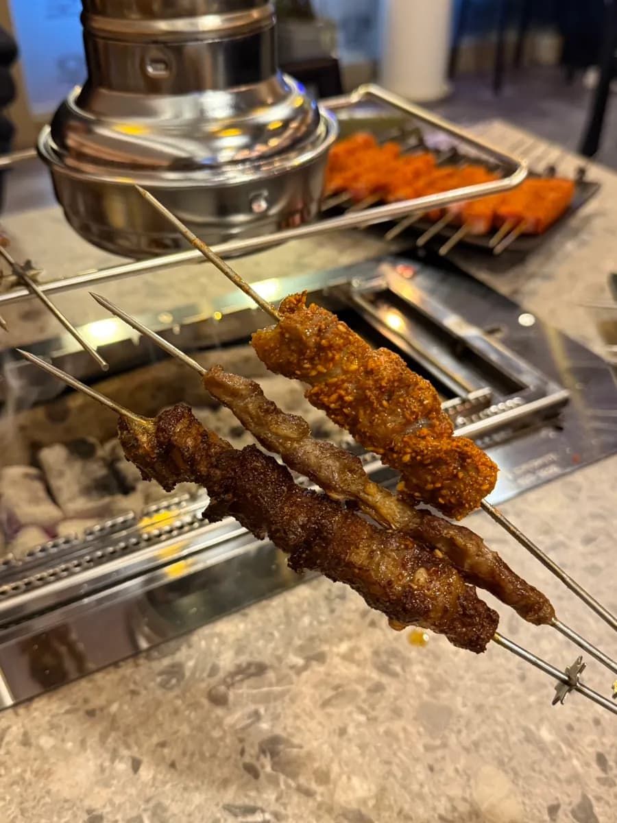 Brochetas de cordero asadas crujientes con carne jugosa por dentro
