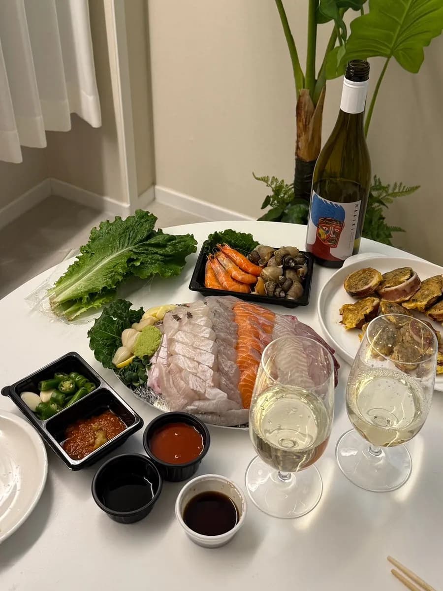 Meja makan dengan sashimi takeout Haesong Hoetjip dan cumi sundae pasar