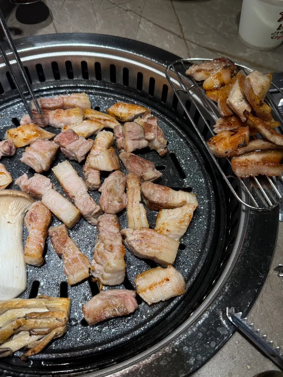 Inihaw na baboy at mushrooms na may puwesto para ilipat ang lutong karne palayo sa direktang init