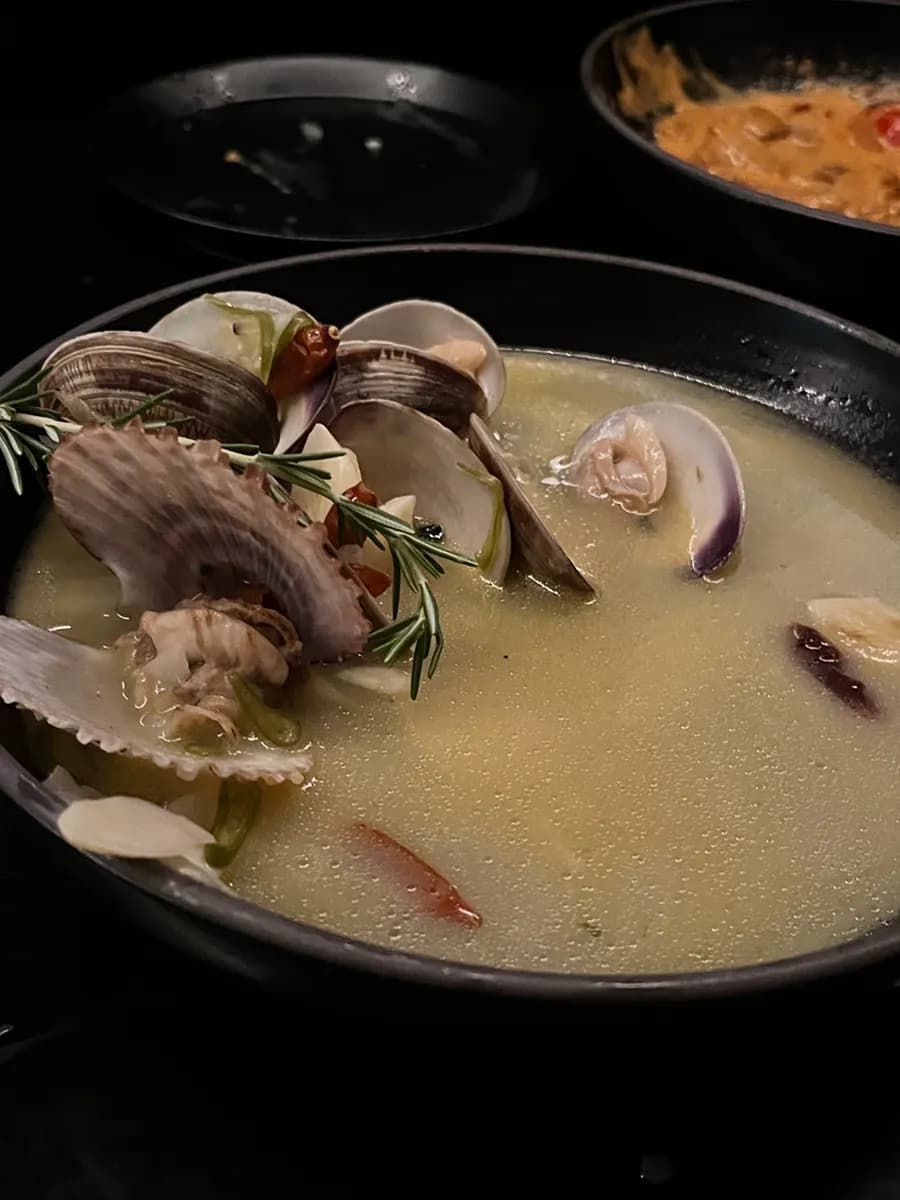Added pasta noodles and prepared clams in the spicy clam stew