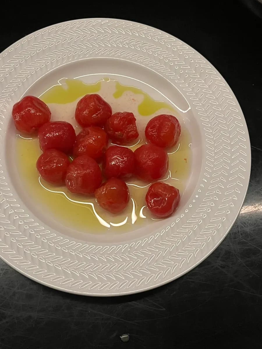 Marinated cherry tomatoes served with olive oil as a service dish
