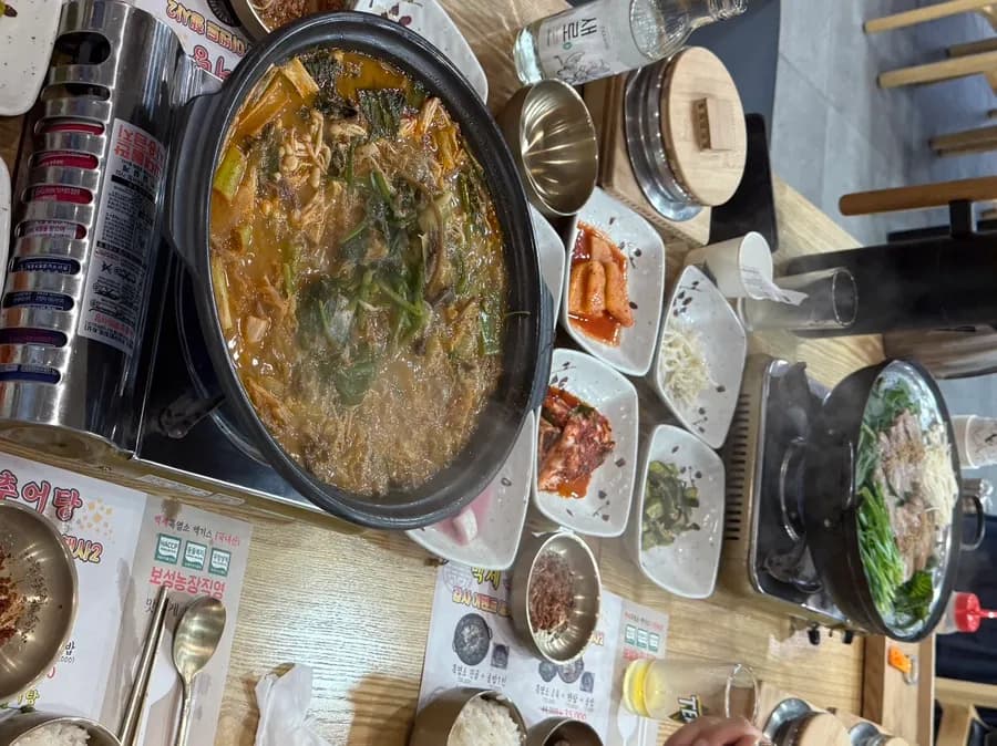 Full table of black goat dishes and sotbap at Baekse Heukyeomso Chueotang