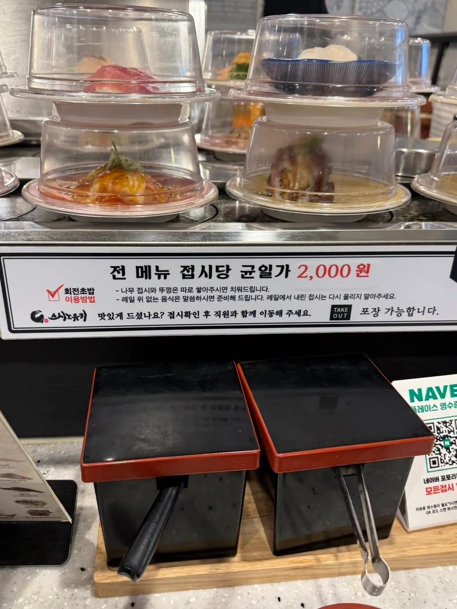 Covered sushi plates on the conveyor belt at Sushino Yuki in Sanbon