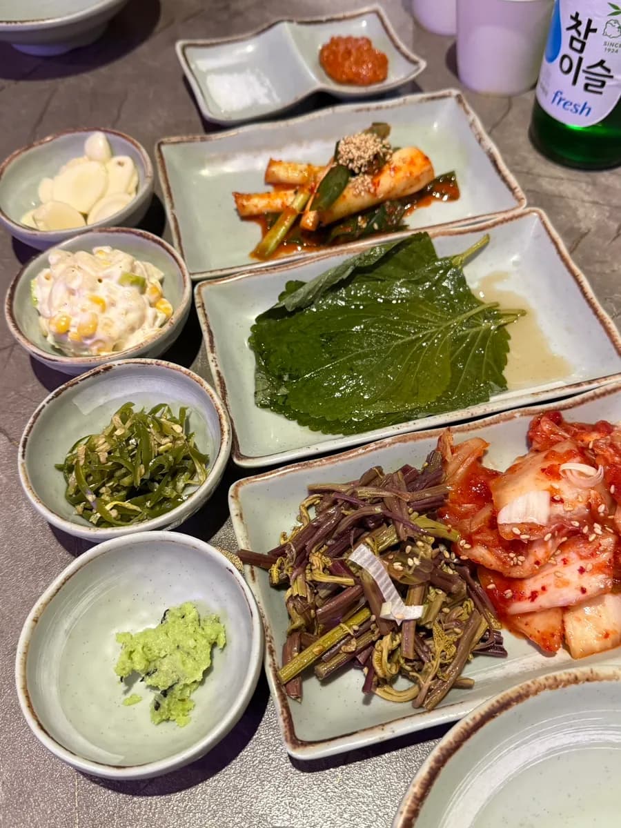 Beilagen für Korean BBQ bei Geunbon Hwaro, darunter Bracken und Kimchi
